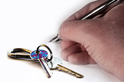 Set of key and a hand signing a rental