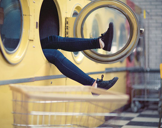Person crawling into a washing machin