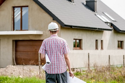 Builder stood in front of house