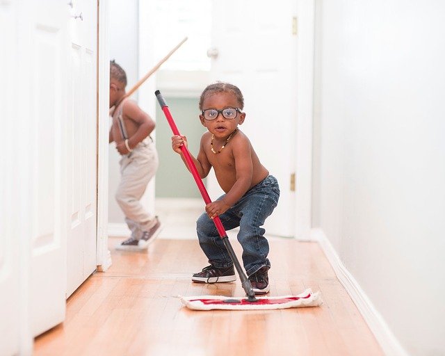 Photo of a child sweeping the floor