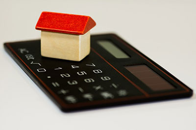 Small toy wooden house on a calculator